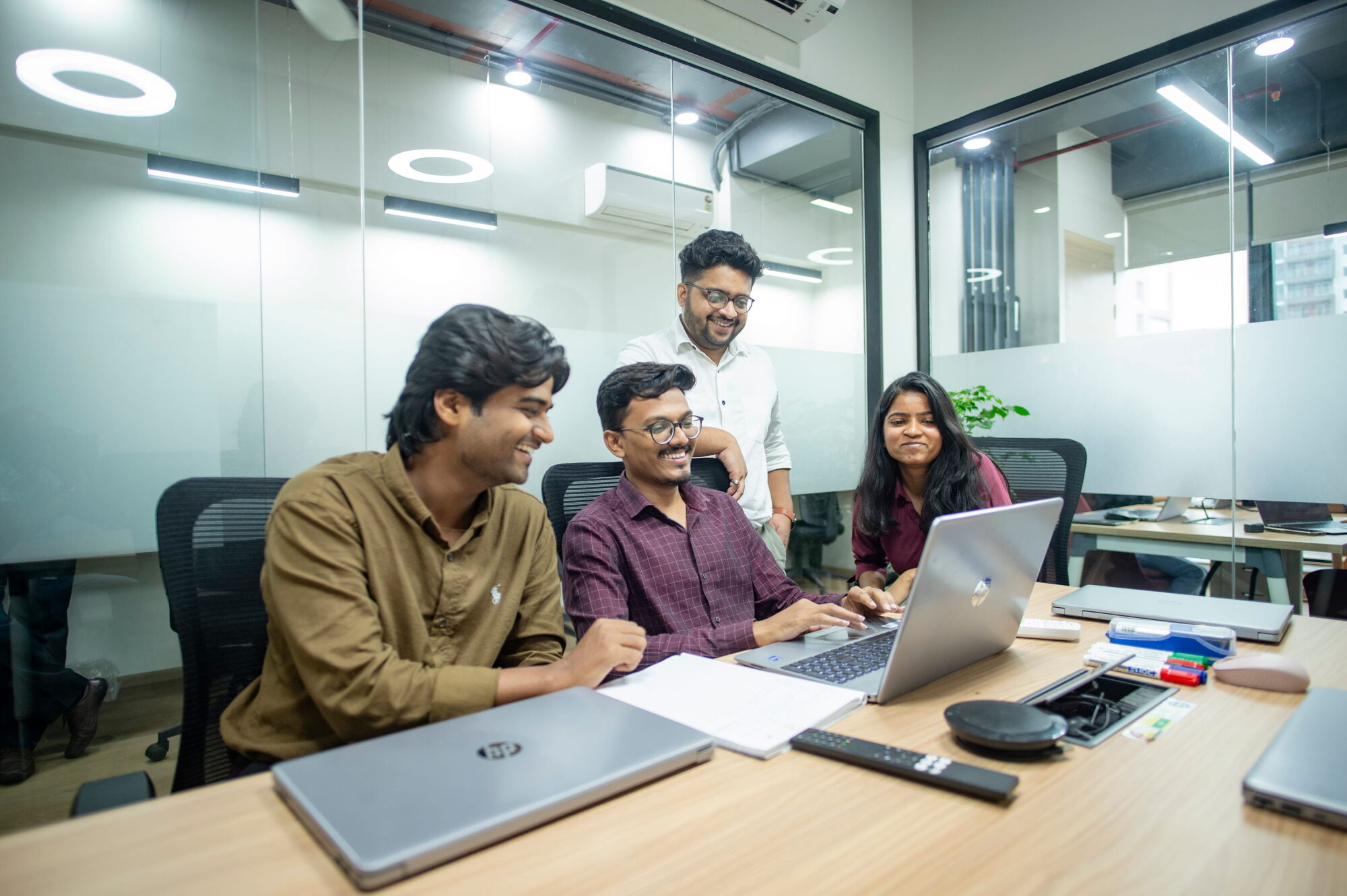 Four VegaCompass consultants working together around a laptop
